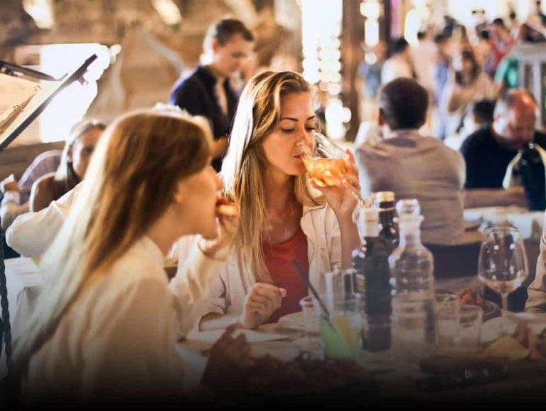 Mulheres tomando vinho e comendo